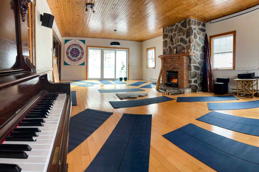 Salle de yoga avec piano et cheminée à Terre de Crystal